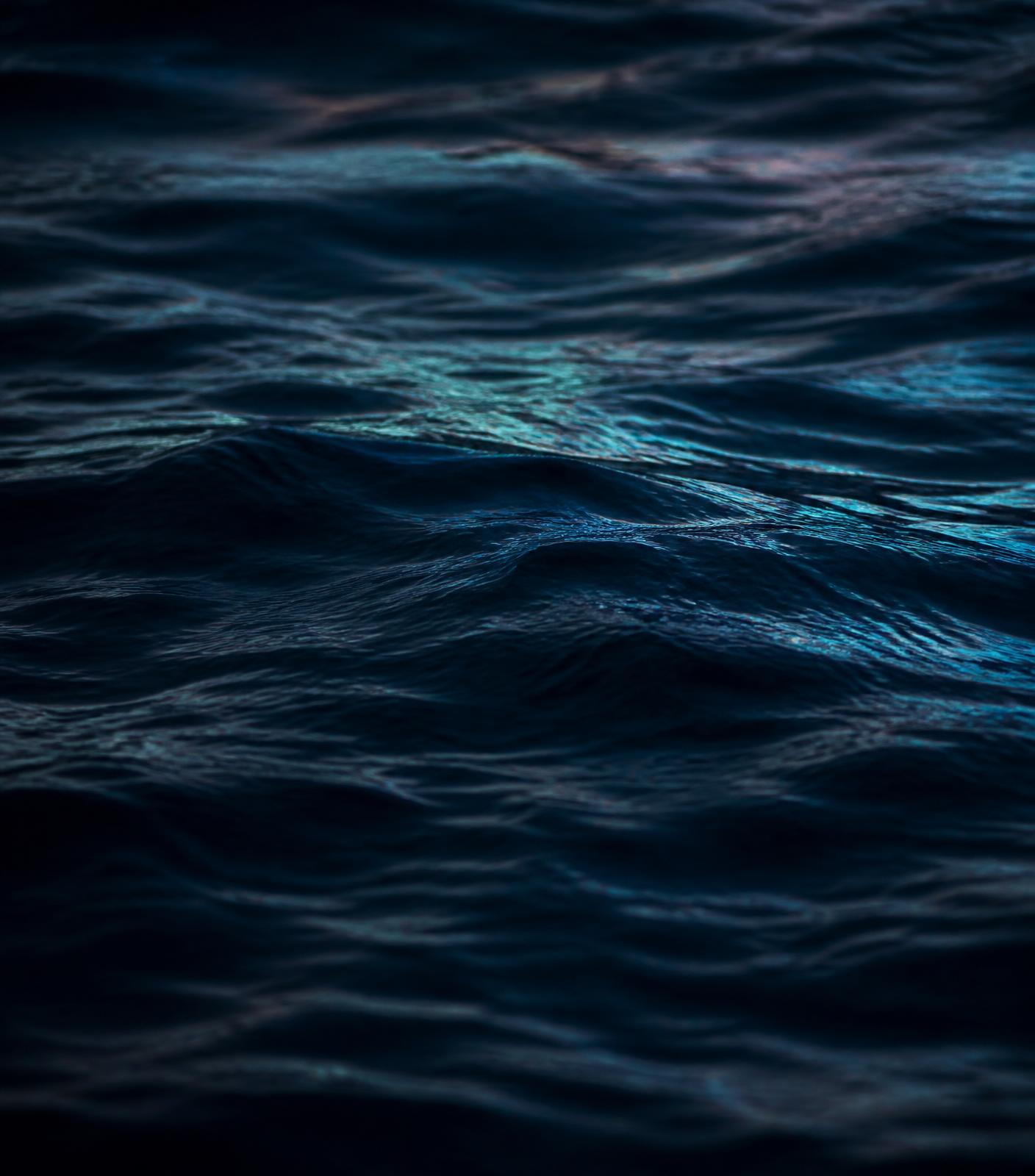 Deep navy ocean water at dusk with aqua reflections